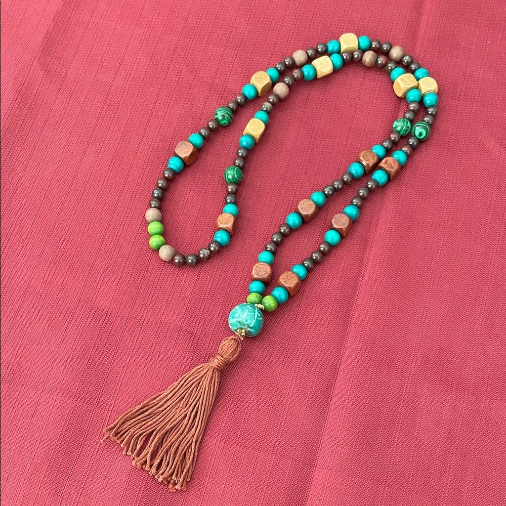 Hand assembled beaded necklace reddish brown cotton tassel